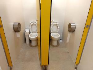 巴塞罗那Boat Barcelona Yacht的浴室设有2个卫生间,浴室设有黄色隔板