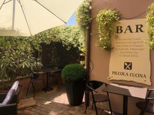 博尔戈马内罗HOTEL DEL CORSO的一间带桌椅和遮阳伞的餐厅