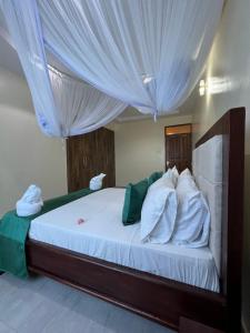蒙巴萨Nitro Homes Nyali的卧室配有带窗帘的大型白色床