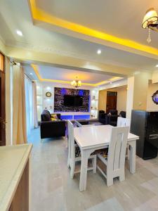 蒙巴萨Nitro Homes Nyali的客厅配有白色的桌子和椅子