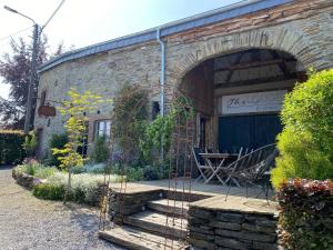 热迪恩Modern Holiday Home in Ardennes with Terrace的砖砌的建筑,设有庭院和桌子