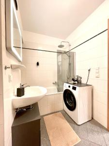 莱比锡Sunshine City Apartment - Leipzig Zentrum - Parkplatz - Netflix的一间带水槽和洗衣机的浴室