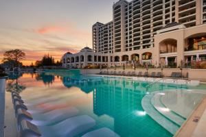 阳光海滩Secrets Sunny Beach Resort and Spa - Premium All Inclusive - Adults Only的大型建筑前的大型游泳池