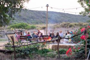 阿尔热祖尔Soul Farm Algarve - Glamping & Farm Houses的一群坐在花园长椅上的人