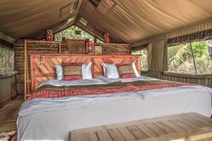 MirapeneSemowi Lodge的帐篷内一间卧室,配有一张大床