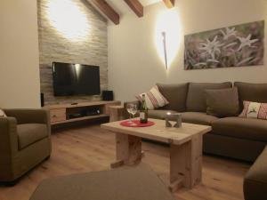 史代比兹Chalet Edelweiss的带沙发、桌子和电视的客厅