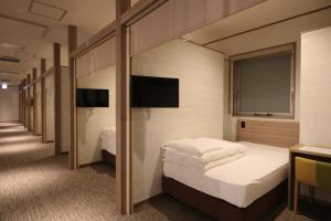 大阪J-SHIP大阪难波客舱胶囊旅馆的酒店客房设有两张床和窗户。