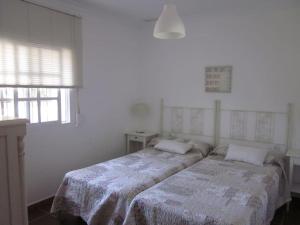 奇克拉纳－德拉弗龙特拉El Magnolio的一间白色客房内带两张床的卧室