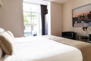 阿姆斯特丹佛兰肯代尔公寓酒店的卧室设有一张白色大床和一扇窗户。