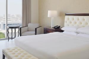 迪拜Delta Hotels by Marriott Dubai Investment Park的酒店的客房 - 带一张床、椅子和窗户