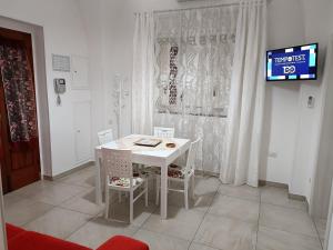 奥里亚LA CASA DEI DESIDERI的带电视的客房内的白色桌椅