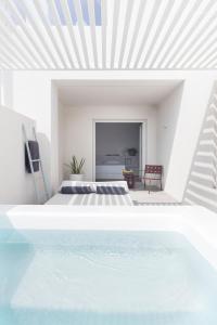 费拉Neo Suites的一间卧室设有一张床和一个游泳池
