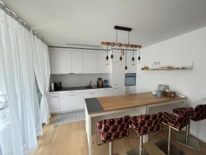 科尔斯腾Wohnung auf dem Bürgenstock的厨房配有白色橱柜和木桌