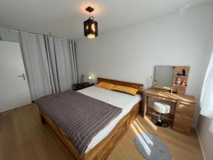科尔斯腾Wohnung auf dem Bürgenstock的一间卧室配有一张床、一张书桌和一面镜子