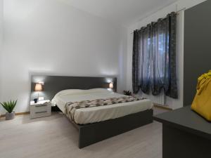 莱科Le Montagne - Le Casette di Osvaldo的一间卧室设有一张大床和两个窗户。