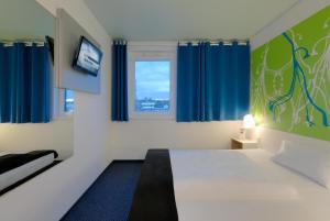 帕德博恩帕德博恩B&B酒店的客房设有床、电视和蓝色窗帘