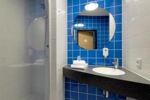 帕德博恩帕德博恩B&B酒店的蓝色瓷砖浴室设有水槽和镜子