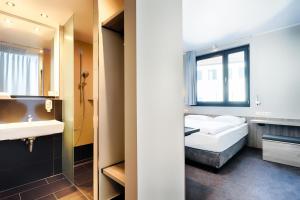 纽伦堡B&B Hotel Nürnberg-Plärrer的一间卧室配有床、水槽和镜子
