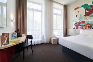 波兹南B&B Hotel Poznań Old Town的酒店客房设有一张床、一张书桌和窗户。