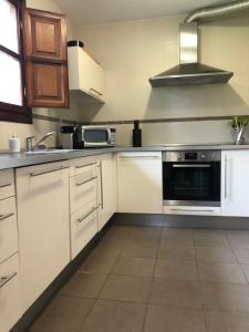 里瓦德塞利亚Casa Mojapies的厨房配有白色橱柜和炉灶烤箱。