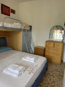 圣多米诺La casetta di India的一间卧室配有双层床和一个带毛巾的梳妆台。