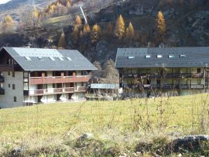 瓦卢瓦尔Studio Valloire, 1 pièce, 4 personnes - FR-1-263-436的建筑旁边的田野上的建筑物