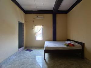 UjungtanjungOYO 92591 Wisma Pangestu Syariah的一间带床的卧室,位于带窗户的房间内