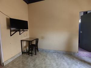 UjungtanjungOYO 92591 Wisma Pangestu Syariah的一间房间,墙上有桌子和电视