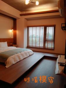 礁溪礁溪朴宿的一间卧室设有一张床和一个大窗户
