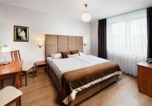 贝谢诺瓦Hotel Bešeňová的酒店客房设有一张大床和一张书桌。
