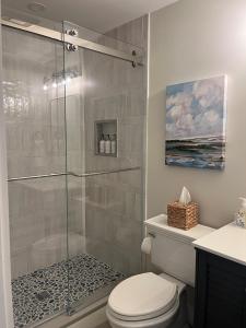 埃德加敦Edgartown Commons Vacation Apartments的一间带卫生间和玻璃淋浴间的浴室