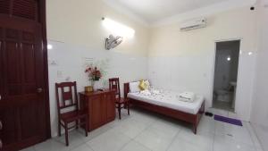 岘港THAI BINH MOTEL的小房间,配有一张床和两把椅子
