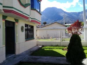 奥塔瓦洛Otavalo Ecuador (casa familiar)的一座带白色围栏和庭院的房子