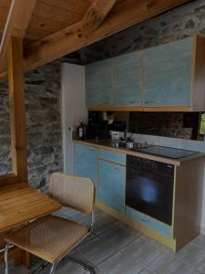 Ponte BrollaRustico Leoro的厨房配有蓝色橱柜、桌子和炉灶。