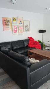 皮拉米德斯港Casa en el mar的客厅里一张黑色皮沙发,配有桌子