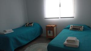 皮拉米德斯港Casa en el mar的客房设有两张床和一张带毛巾的桌子。