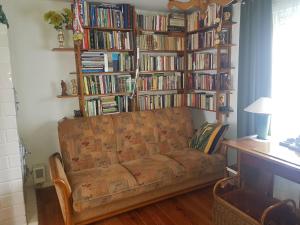 奥古斯图Dom u Wojciecha的客厅配有沙发和书架,书架上装满了书籍