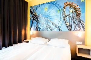 埃滕海姆B&B Hotel Rust-Ettenheim的一间卧室配有一张床和一张摩天轮的海报