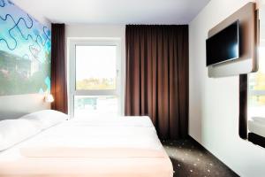 拉芬斯堡B&B Hotel Ravensburg的酒店客房设有两张床和一台平面电视。
