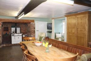埃克塞特Ashclyst Farm Rural Retreat的一间带木桌和椅子的用餐室