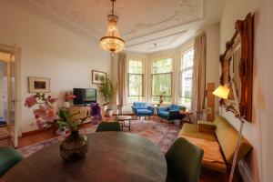 卑尔根Villa Juttershof的客厅配有桌子和蓝色椅子