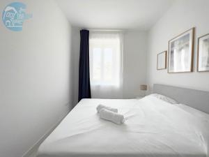 穆贾San Rocco Sweet Apartments的卧室内的白色床和毛巾