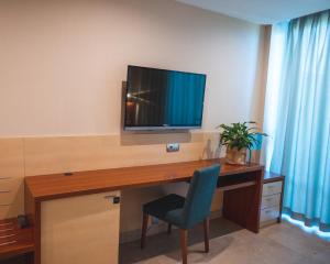 贝尼多姆德鲁斯四星级高级酒店的客房设有书桌、电视和椅子
