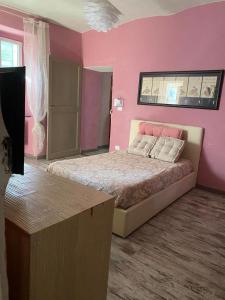 阿奎泰尔梅Villa Gioia的粉红色的卧室配有一张床和一张桌子