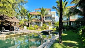 贝尔马尔Beach Penthouse BELMARE的一个带游泳池和棕榈树的度假村