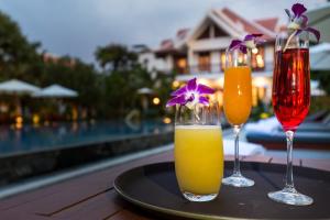 暹粒Angkor Privilege Resort & Spa的池畔餐桌上的两杯饮料