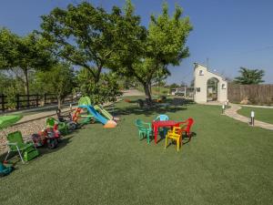 阿斯蒂Casa del Rosmarino的草地上设有五颜六色的桌椅的游乐场