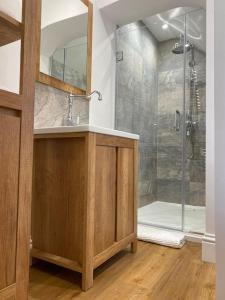 欧卡里Luxury Self Catering Studio with vaulted ceiling的带淋浴、水槽和镜子的浴室