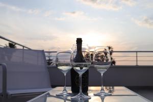 梵蒂冈角SUNSEA - Enjoy Your Family的阳台上的一瓶葡萄酒和两杯酒