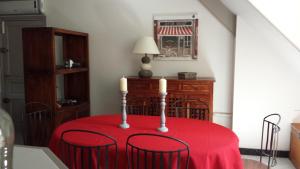 圣马丹勒博瓦雷公寓的一张桌子,上面有红桌布和三根蜡烛